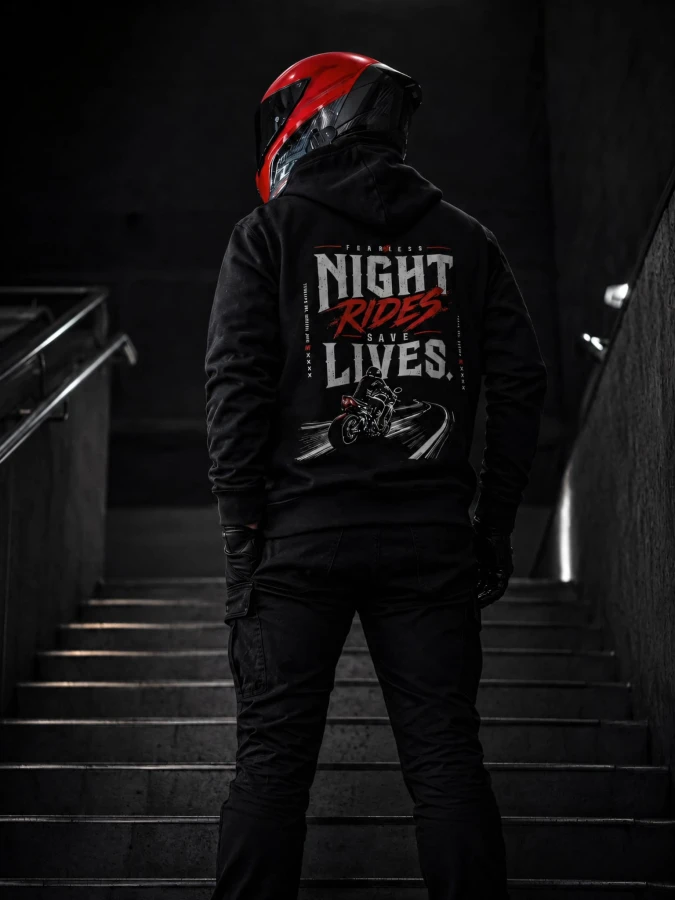 Bluza Night Rides Save Lives FEARLESS prezentowana na schodach z widocznym nadrukiem na plecach w nocnym klimacie.