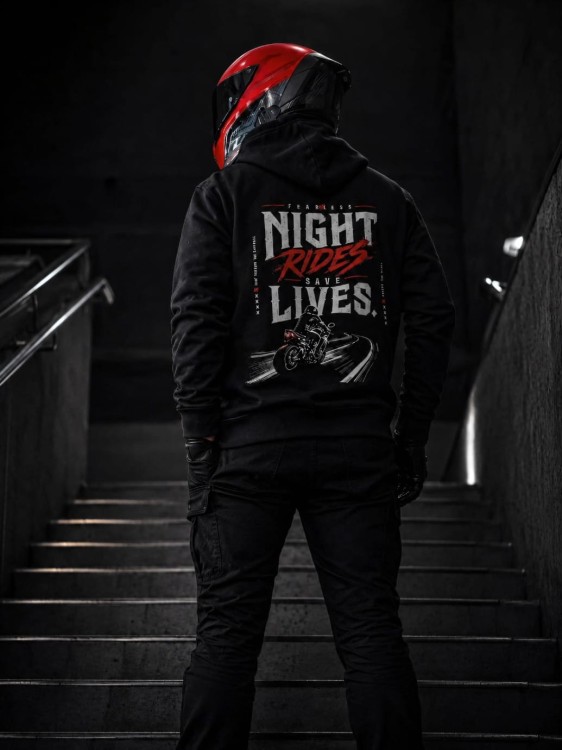Bluza Night Rides Save Lives FEARLESS prezentowana na schodach z widocznym nadrukiem na plecach w nocnym klimacie.