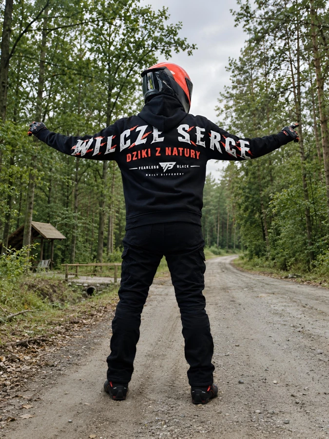 Czarna bluza motocyklowa WILCZE SERCE - motocyklista w lesie z rozłożonymi rękami